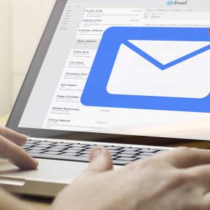 online business concept: man using a laptop with mail on the screen. Screen graphics are made up.