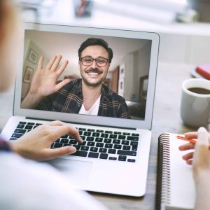 Client waving during video chat on laptop as part of Cindari's support options